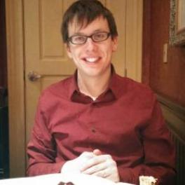 Craig Jendza in a red button down top sitting at a table